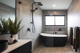 Frameless glass shower screens in modern white tiled bathroom